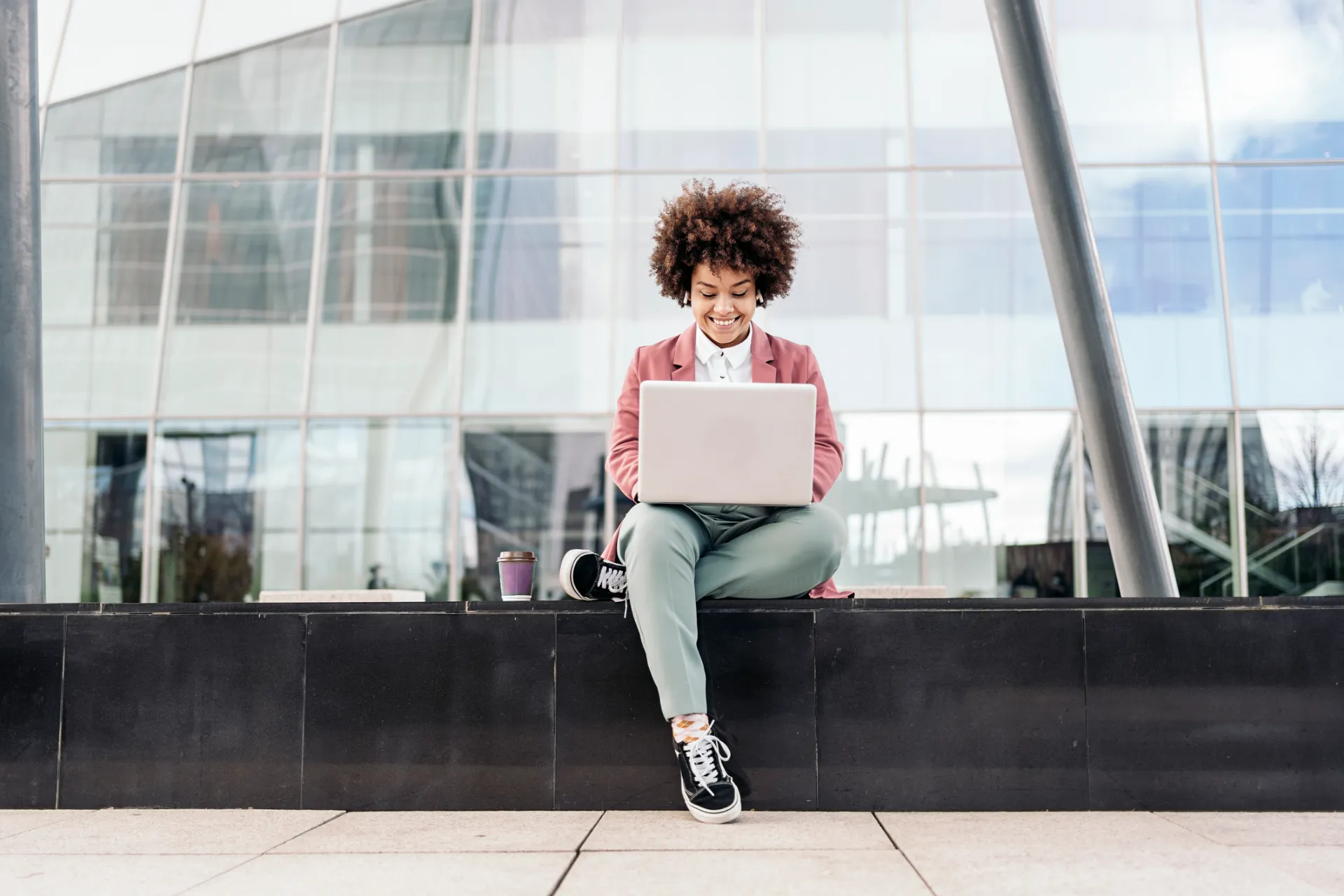 Salariée internationale travaillant devant un immeuble de bureaux à Londres dans le cadre d'un visa Global Business Mobility